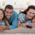 Smiling family on floor in living-room