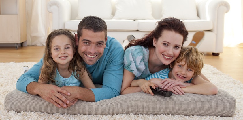 Smiling family on floor in living-room